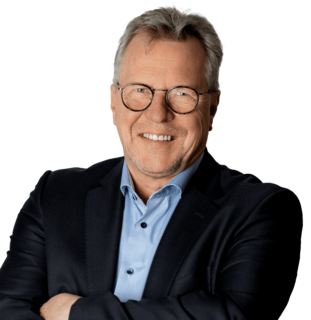 Älterer Mann mit Brille und Anzug lächelt frontal